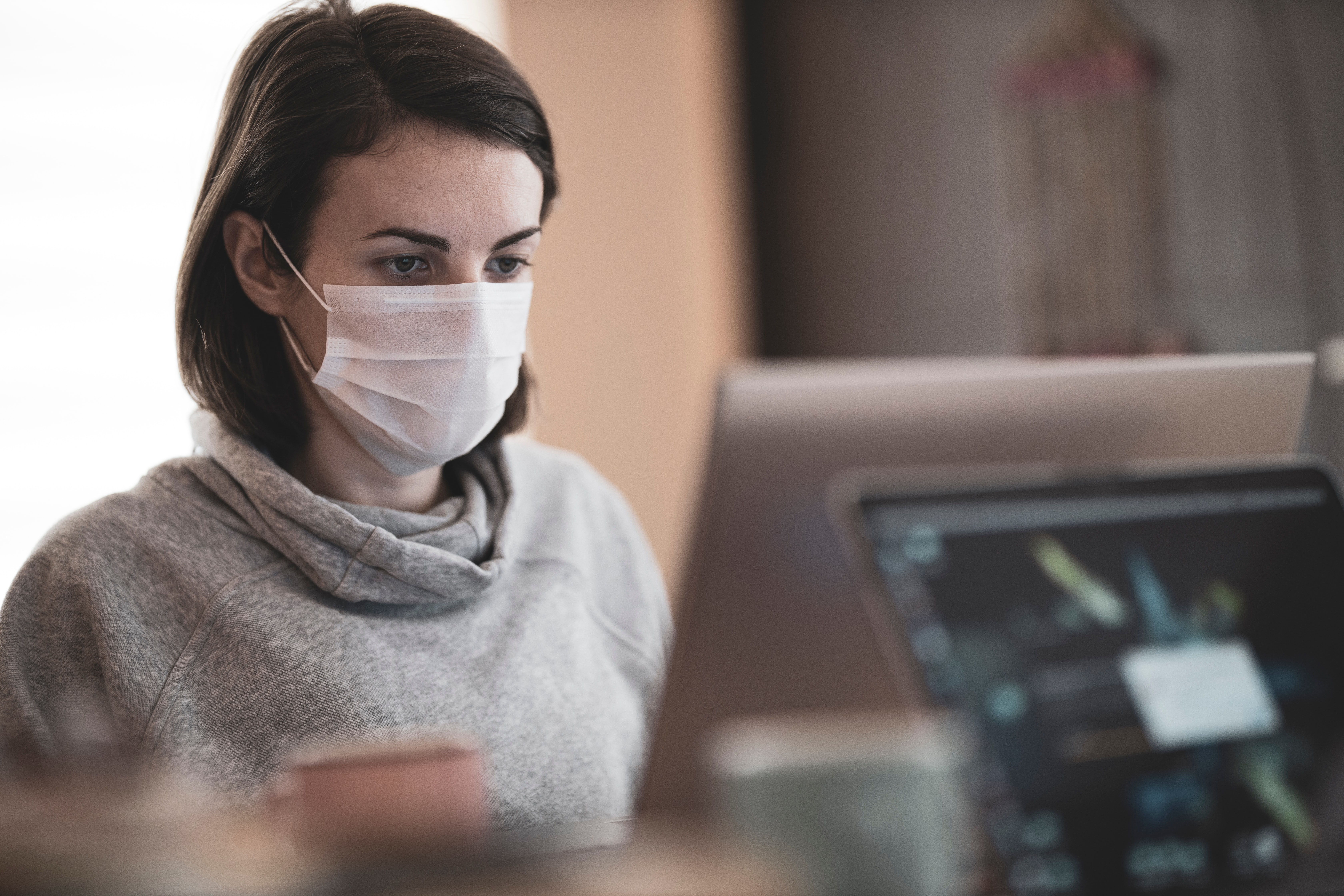 Woman with mask using a desktop computer