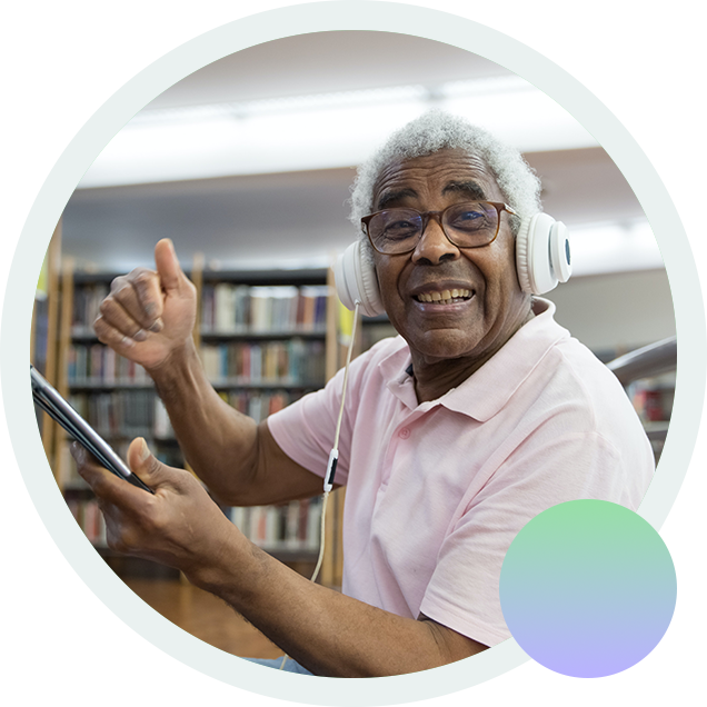 A man points to a library tablet, successful in his search for digital media.