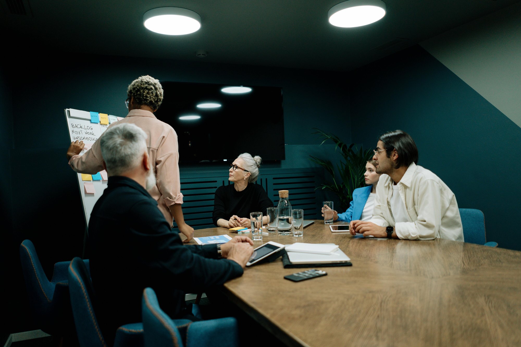 A collaborative team look over a white board.