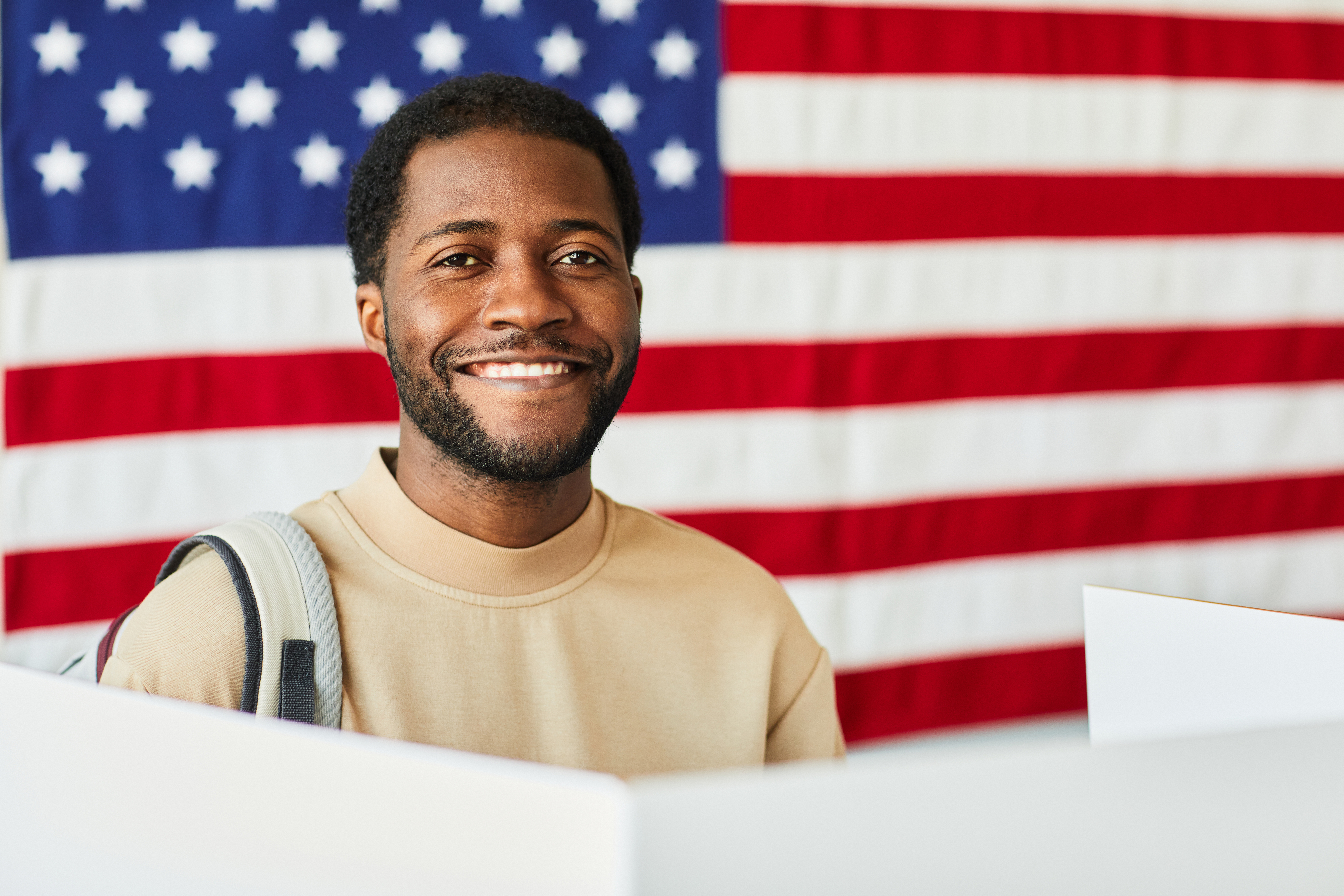 Portrait of smiling  man voting against USA banner background