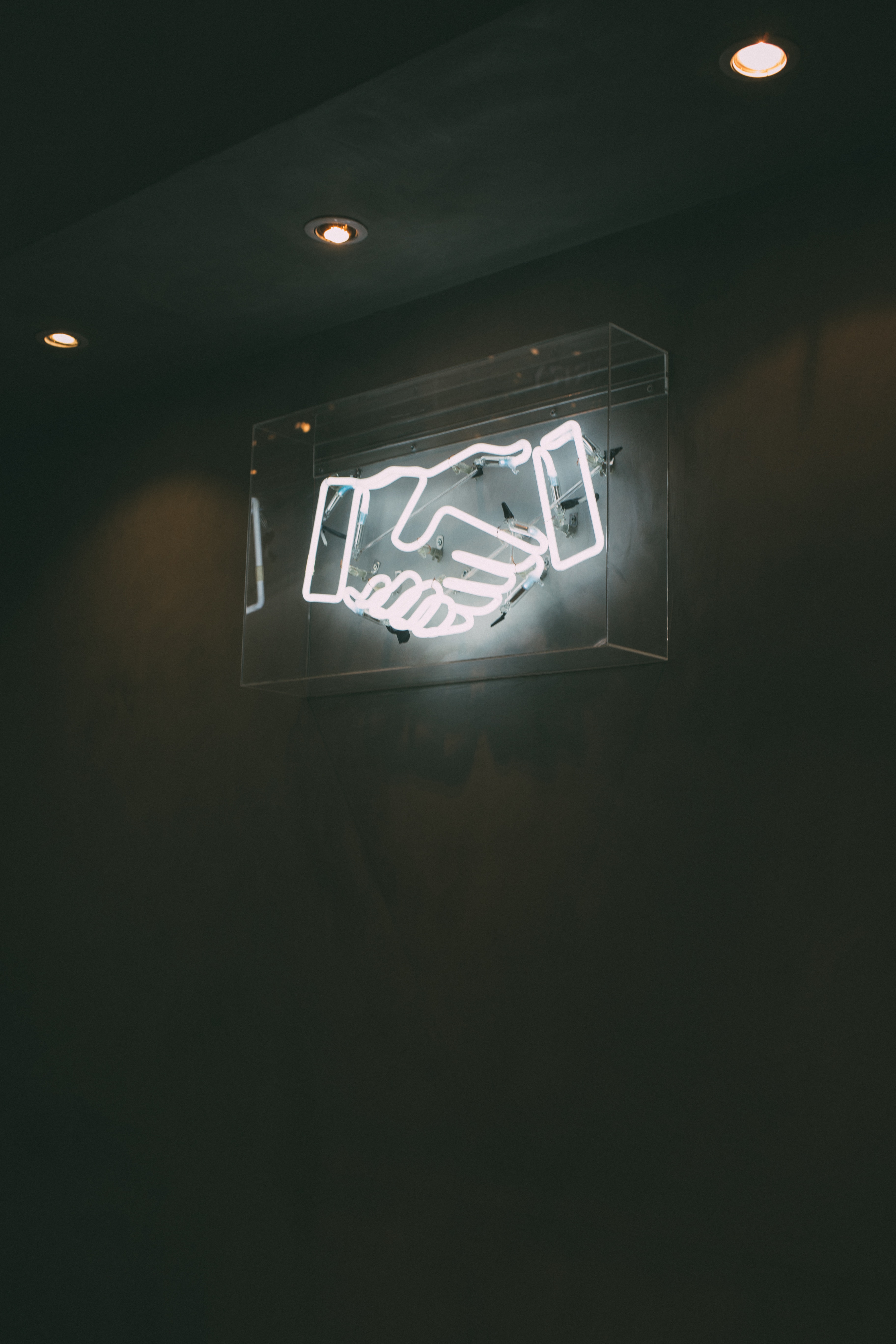 picture of neon sign of two hands shaking